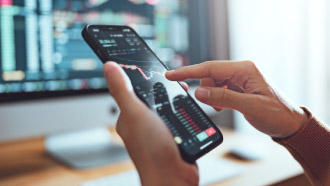 Na imagem vê-se alguém a segurar um telemóvel com as mãos